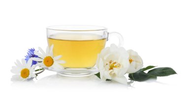 Cam bardakta aromatik bitki çayı ve beyaz bardakta izole edilmiş çiçekler.