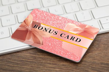 Şık tasarımı olan bonus kart ve ahşap masada bilgisayar klavyesi