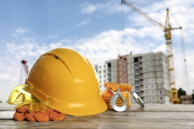 İnşaat alanına karşı masada güvenlik ekipmanları var.