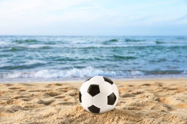 Plaj futbolu. Denize yakın kumda futbol topu. Mevsimlik açık hava aktivitesi