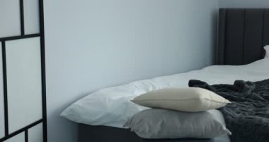 Yatağın üzerinde yün battaniye, kamera sağa hareket ediyor.