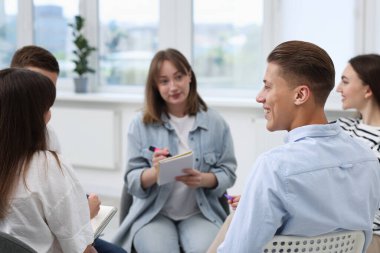 Yaşam koçluğu dersinde kapalı alanda toplantı yapan bir grup insan.