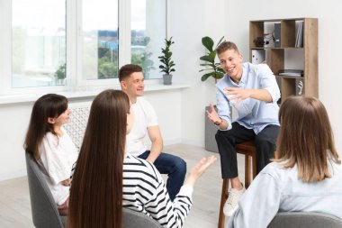 Yaşam koçluğu dersinde kapalı alanda toplantı yapan bir grup insan.