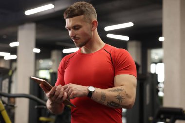 Spor merkezinde tableti olan kişisel antrenör.