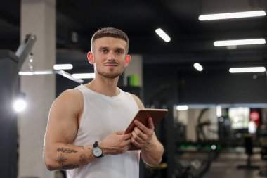 Spor merkezinde tableti olan kişisel antrenör. Metin için boşluk