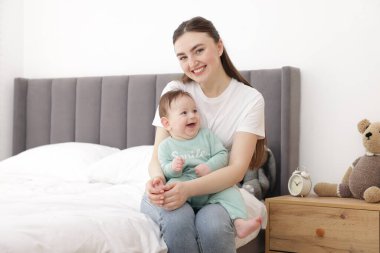 Anne, evde yatağında sevimli küçük bebeğiyle.