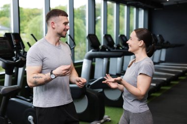 Spor merkezinde konuşan profesyonel kişisel antrenörler.