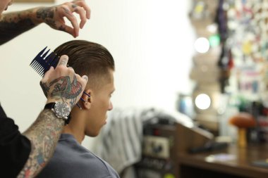 Berber dükkanında müşteriyle çalışan profesyonel berber, yakın plan. Metin için boşluk