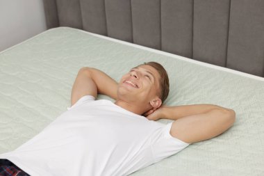 Evdeki yumuşak yatakta uzanan mutlu adam, manzaranın üstünde.