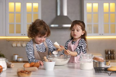 Yemek tarifi. Sevimli çocuklar mutfaktaki masada kurabiye için para kazanıyor.