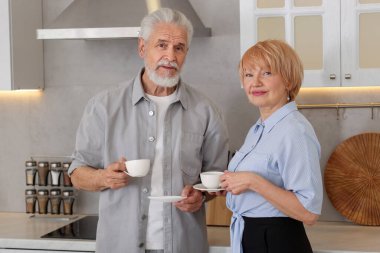Mutfakta kahve içen sevimli yaşlı çift.