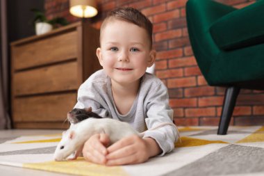 Evinde yerde fareleri olan küçük bir çocuk.