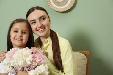 Anne ve kızı evde bir buket güzel şakayıkla