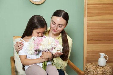 Anne ve kızı evde bir buket güzel şakayıkla