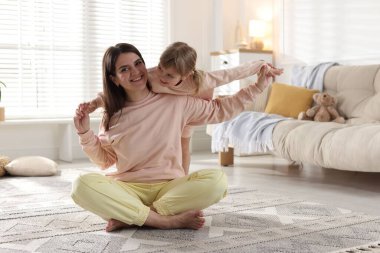 Mutlu anne ve tatlı kızı evde yerde yatıyor.