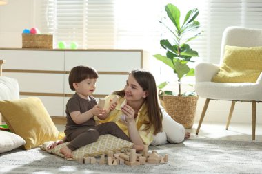 Anne ve oğlu evlerinde tahta yapı taşlarıyla oynuyorlar.