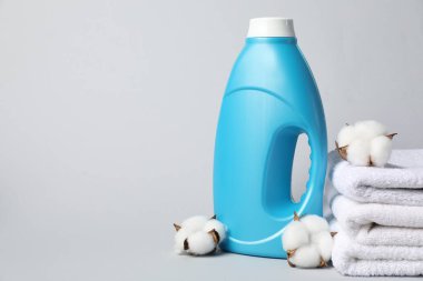 Açık gri arka planda kumaş yumuşatıcı, havlu ve pamuk çiçekleri, metin için boşluk