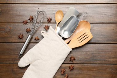 Fırın eldiveninde farklı mutfak aletleri ve ahşap masada anason yıldızları.