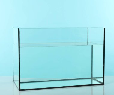 Beyaz masada turkuaz arka planda su bulunan cam akvaryum