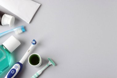 Açık gri arka planda farklı oral bakım ürünleri. Metin için boşluk