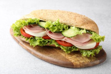 Jambonlu ve sebzeli baget sandviç açık gri masada, yakın plan.