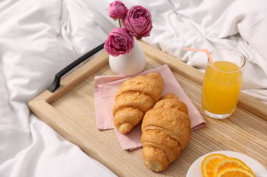 Nefis bir kahvaltı tepsisi ve çiçeklerle kapalı bir yerde, yakın plan.