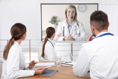 Doktorlar konferans sırasında kapalı alanda video projektör kullanıyorlar. Projeksiyon ekranında hoparlör