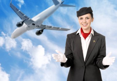 Gülümseyen hostes mavi gökyüzüne karşı uçakla ve bulutlarla