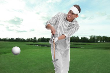 Golfçü topa vuruyor.