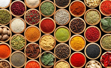 Siyah arka plandaki kaselerde farklı aromatik baharatlar dizisi.