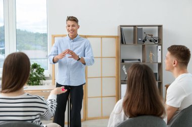 Yaşam koçluğu dersinde kapalı alanda toplantı yapan bir grup insan.