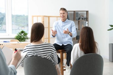 Yaşam koçluğu dersinde kapalı alanda toplantı yapan bir grup insan.