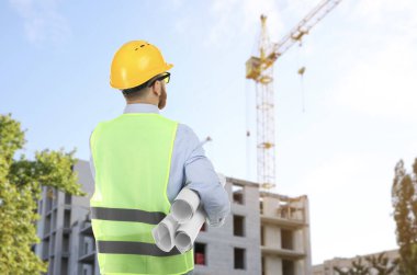 İnşaat alanına bakan güvenlik ekipmanı mühendisi.