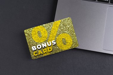 Gri masada şık tasarım ve dizüstü bilgisayarı olan bonus kart.