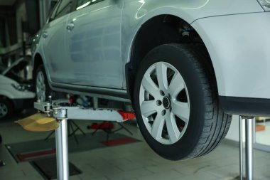 Araba servisinde lastik değiştirirken kaldırılmış, yakın plan.