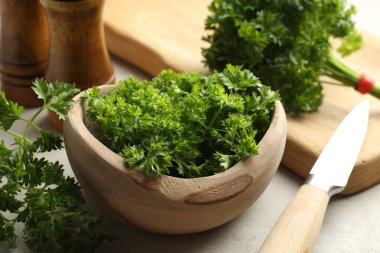 Taze maydanoz, baharatlar ve bıçak ışık masasında, yakın plan.