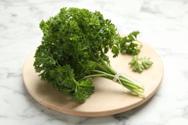 Beyaz mermer masada bir demet taze maydanoz, yakın plan.