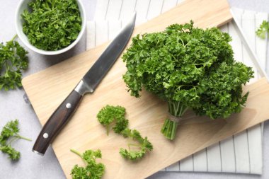 Taze maydanoz ve bıçak masanın üzerinde, düz yatıyordu.