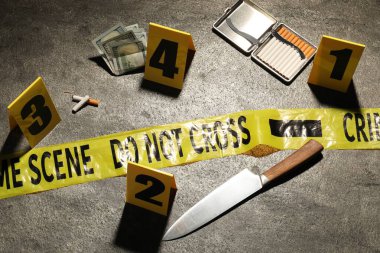 Adli tıp uzmanlığı. Gri arka planda delil, işaret ve polis bandı bulunan suç mahalli