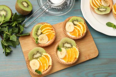 Meyveli tart ve açık mavi ahşap masada nane şekeri, düz. Tatlı nefis.