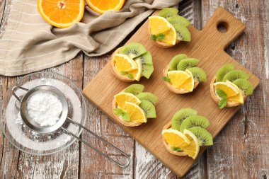 Meyveli tart, nane ve pudra şekeri ahşap masada, düz bir şekilde. Tatlı nefis.