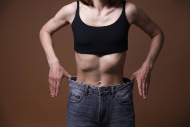 Kahverengi arka planda iştahsızlık çeken kadın, yakın plan.