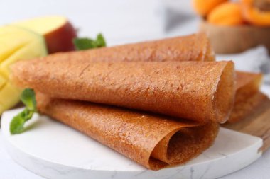 Lezzetli meyve dürümleri, nane ve mango masada, yakın plan.