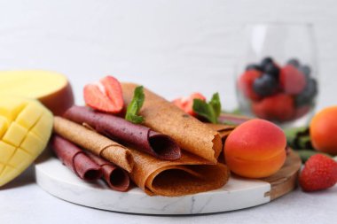 Lezzetli meyve dürümleri, nane, mango ve böğürtlen ışık masasında, yakın plan.