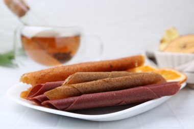 Lezzetli meyve dürümleri beyaz masada, yakın plan.