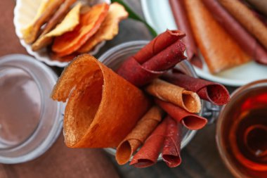 Lezzetli meyve dürümleri ve ahşap masada çay, yakın plan.