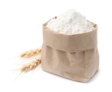 Kese kağıdında buğday unu ve beyaz arka planda çiviler.