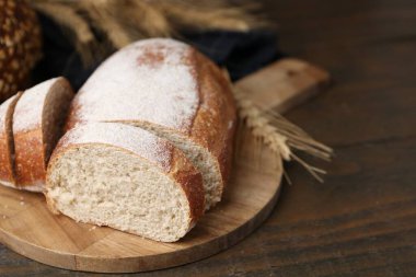 Taze kesilmiş ekmek ve çiviler ahşap masada, yakın plan.