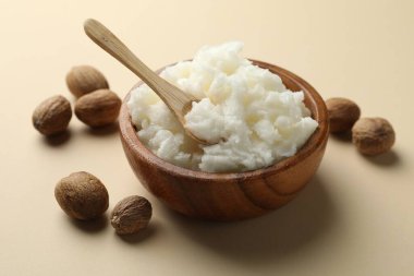 Bej arka planda doğal Shea yağı ve fındık, yakın plan.