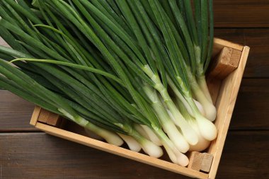 Tahta masadaki sandıkta taze taze taze soğanlar.